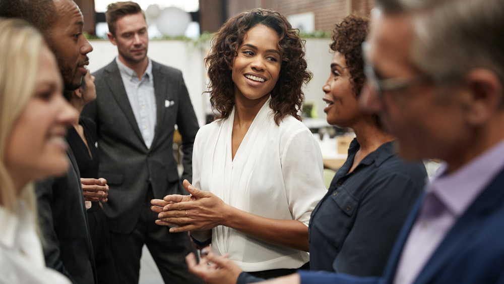 Business Team Standing Having Informal Meeting In Modern Office