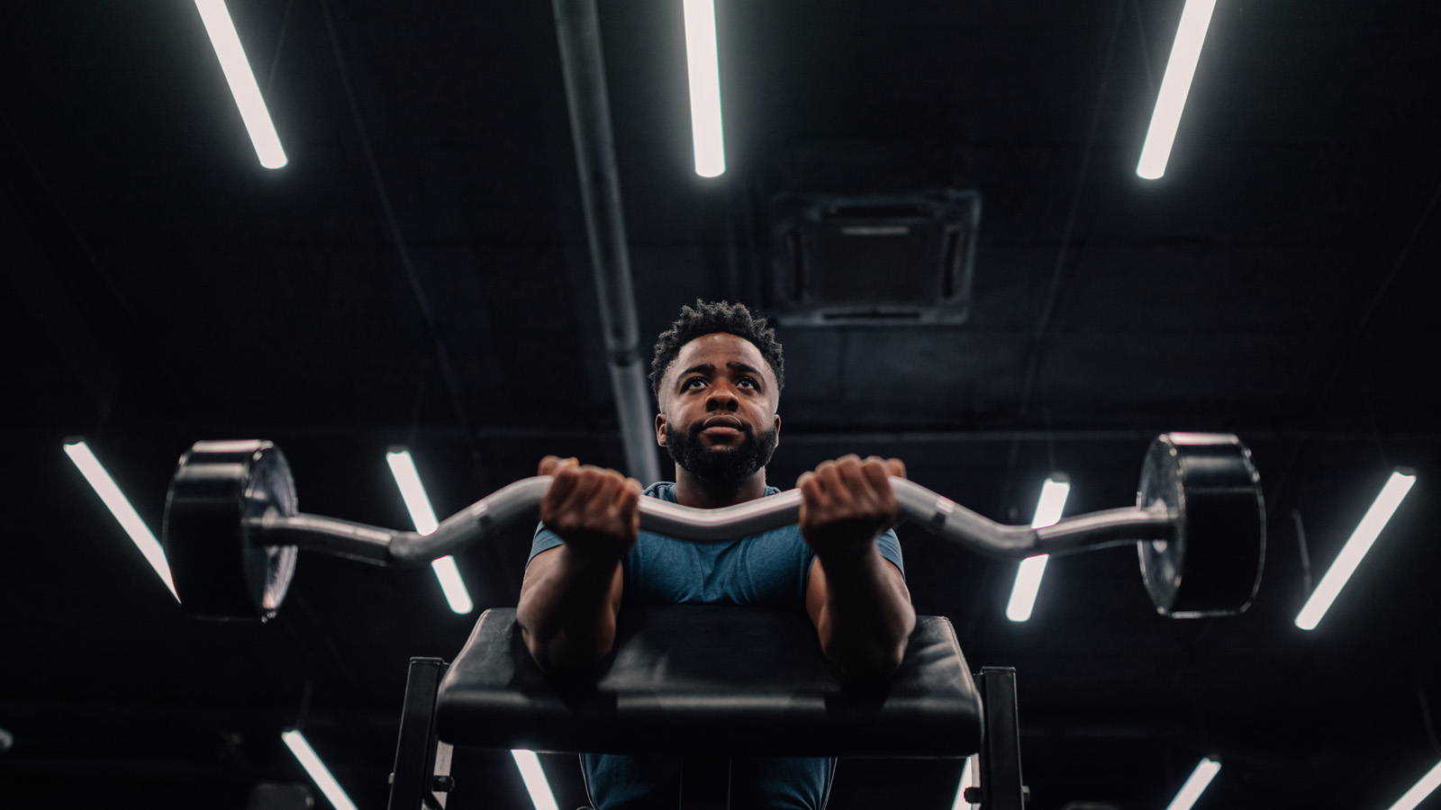 Empty gym with single person lifting weights