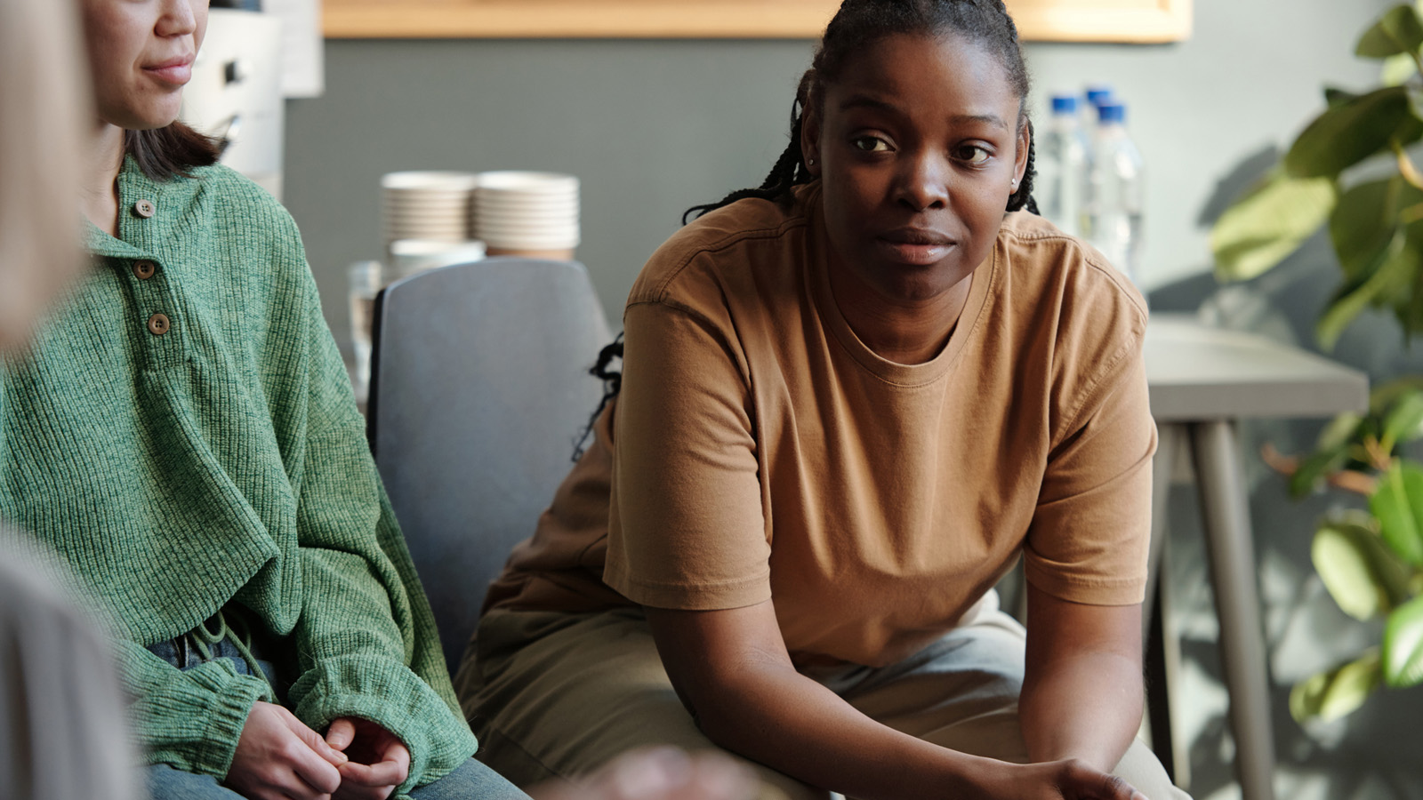 A subtle, warm-toned candid of a woman sitting in a classroom, engaged and joyful